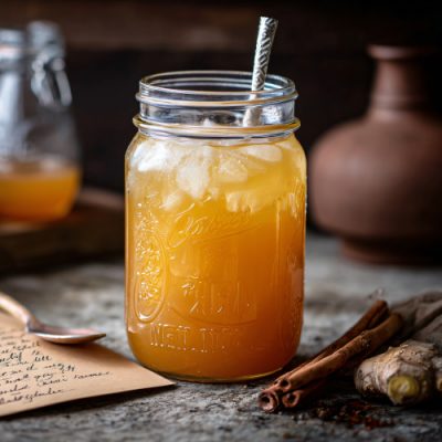 Apple-ginger switchel in a mason jar, styled with a handwritten recipe card
